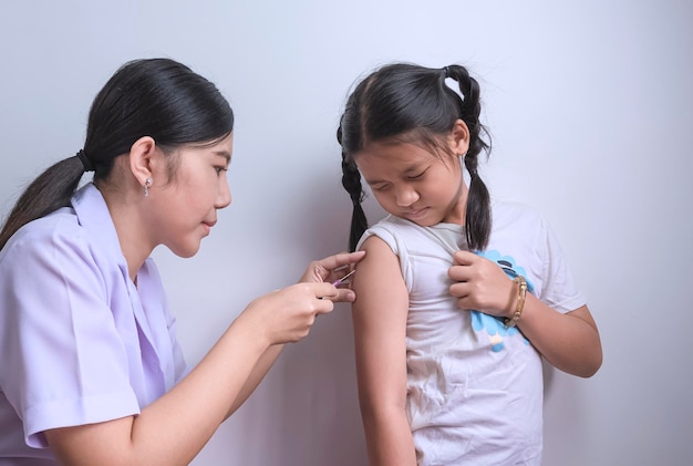 Premium Photo | Asian female nurse giving vaccine to little girl ...