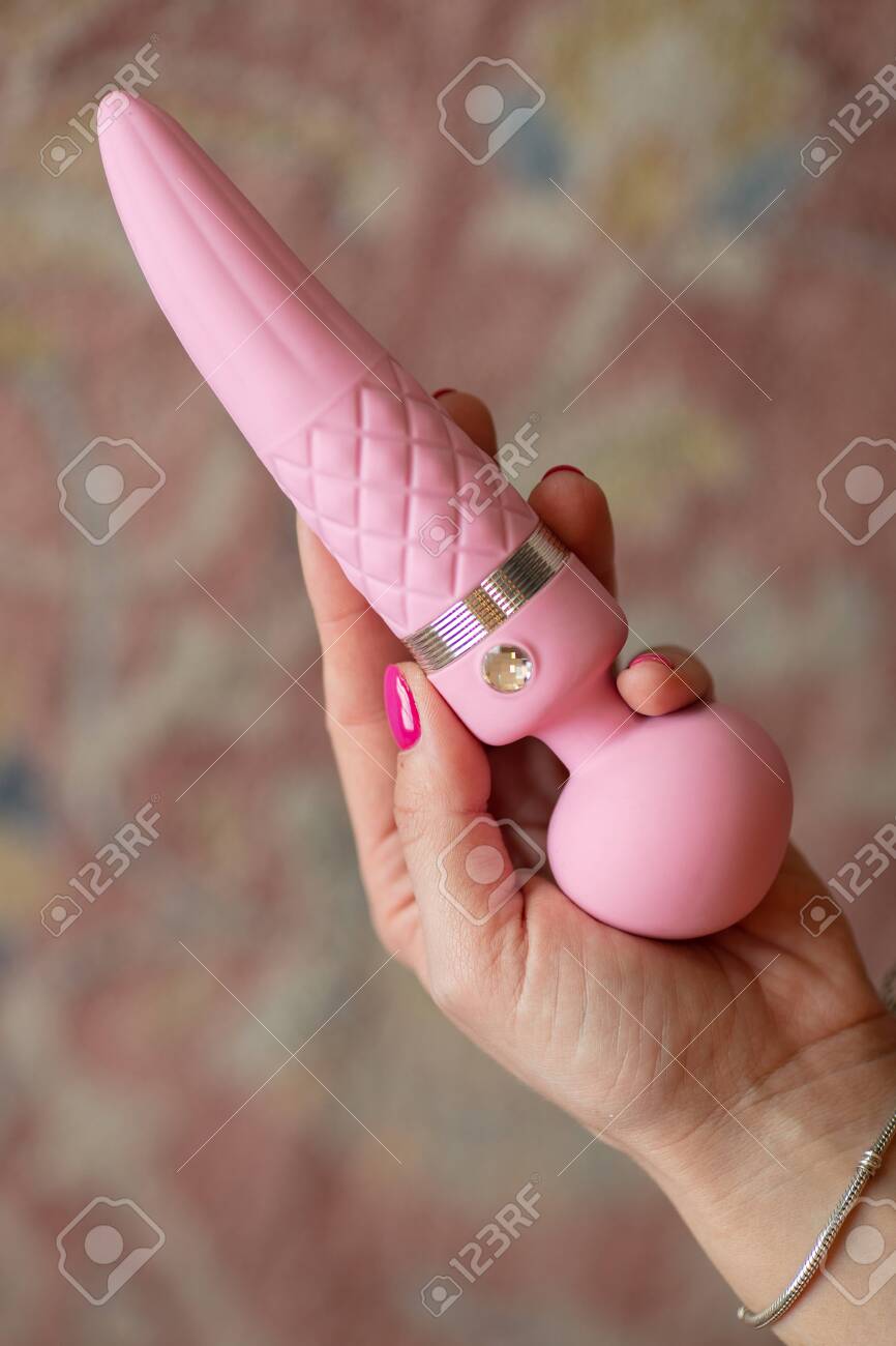 The Girl Holds In Her Hand A Pink Massager For Sex. Vibrator For ...