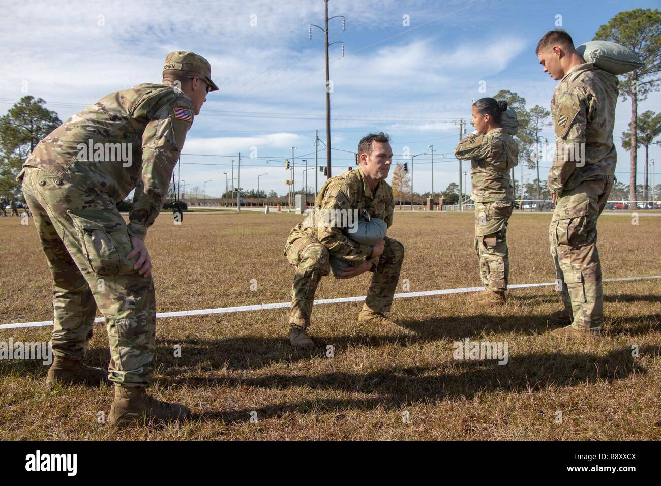 Soldiers of the 3rd Infantry Division perform squats with sandbags ...