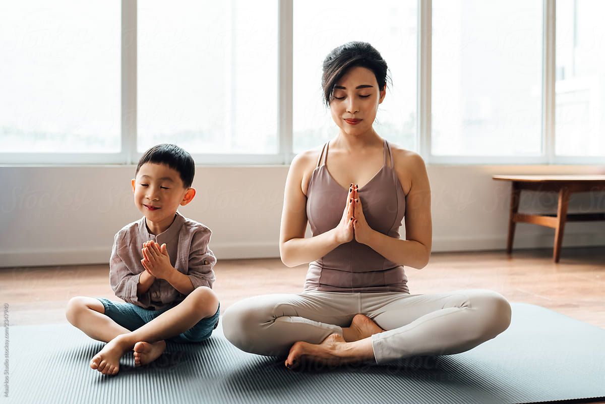 Mother And Son Practicing Yoga At Home