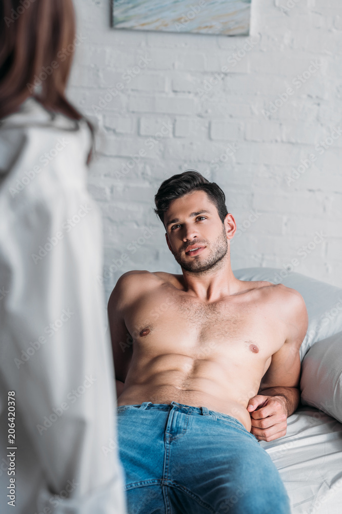 handsome sexy boyfriend lying on bed and looking at girlfriend ...