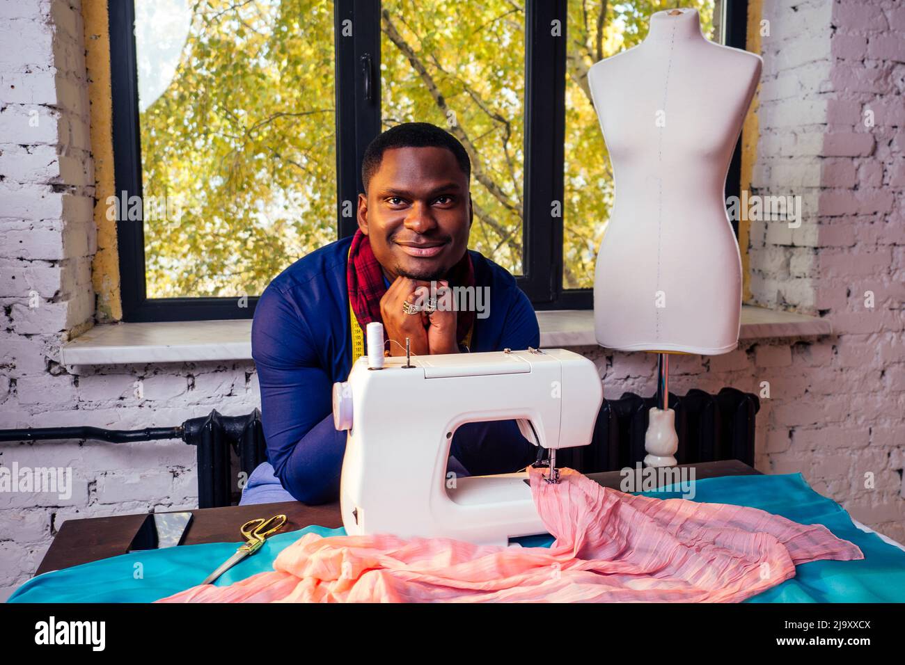 portrait of a handsome african man smiling seamstress with sewing ...