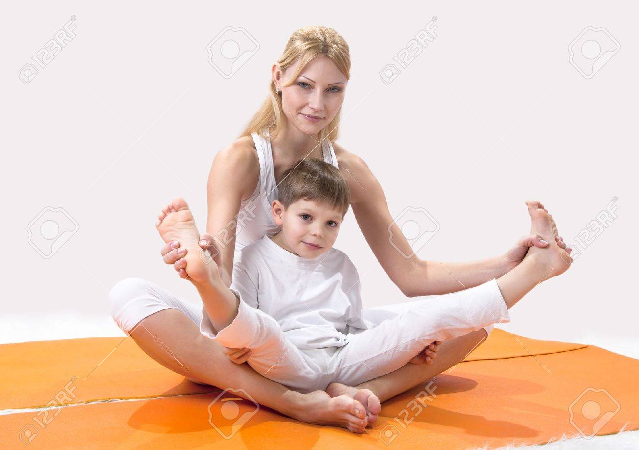A Beautiful Young Mother Practices Yoga With Her Son Stock Photo ...