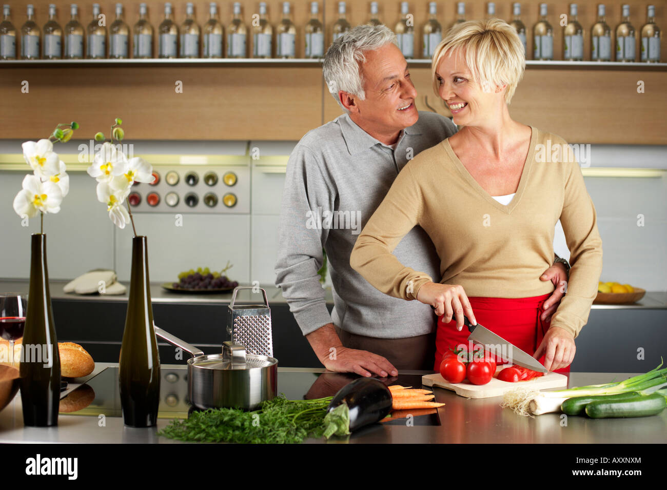 Blond woman and gray-haired man cooking together Stock Photo - Alamy