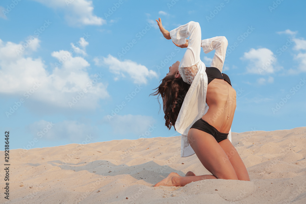 Stunning flexible female gymnast posing gracefully in the desert ...