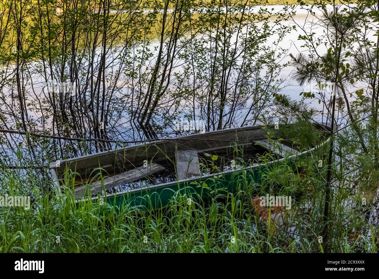 Small fishing boat abandoned and filled with water at edge of Imp ...