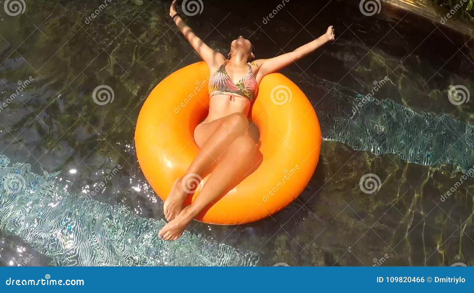 Young Mixed Race Woman in Bikini Relaxing on Tube in Swimming Pool ...