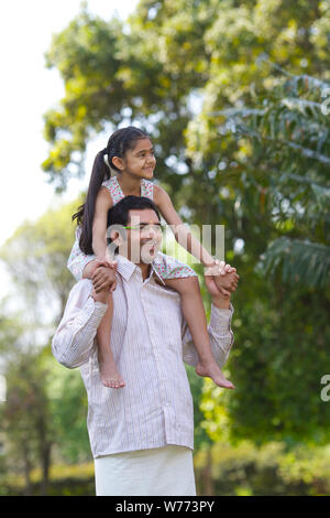 South Indian man carrying his daughter on his shoulders Stock ...