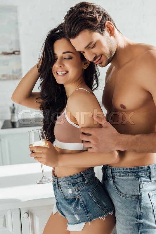 Boyfriend hugging sexy girl with glass of wine from behind | Stock ...