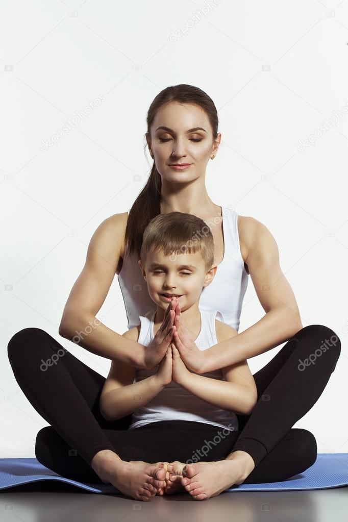 Mother and son doing yoga (sports exercises), have fun and spend a ...
