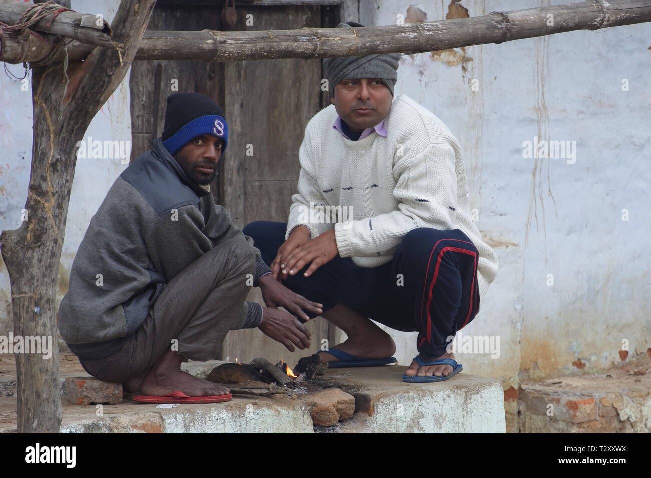 Two Indian poor men are comforting themselves by wood-fire in ...